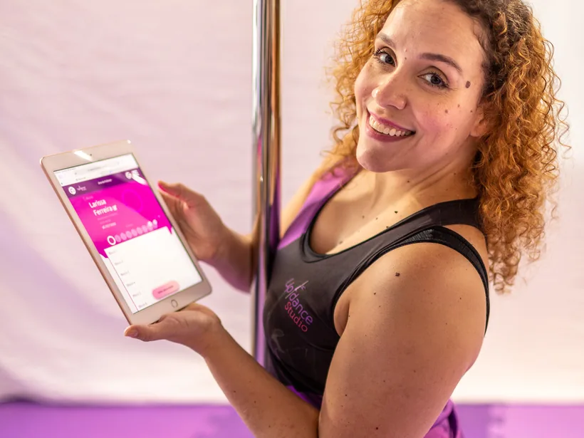 Professora da Up com o registro de progresso da aluna no tablet